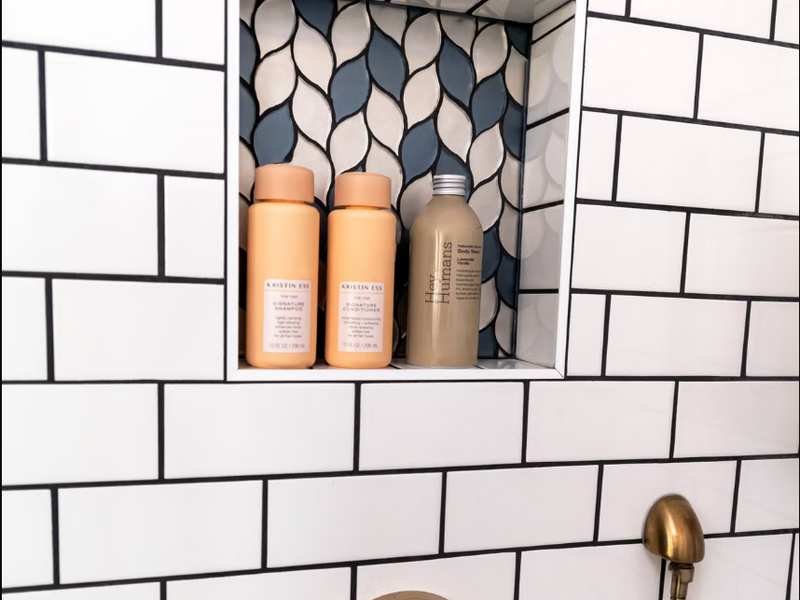 Nicho de banheiro revestido com azulejo em mosaico e produtos organizados dentro