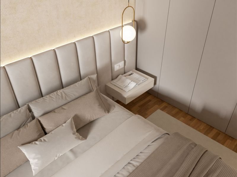 Detalhe de cabeceira estofada com almofadas em tom neutro sobre cama box